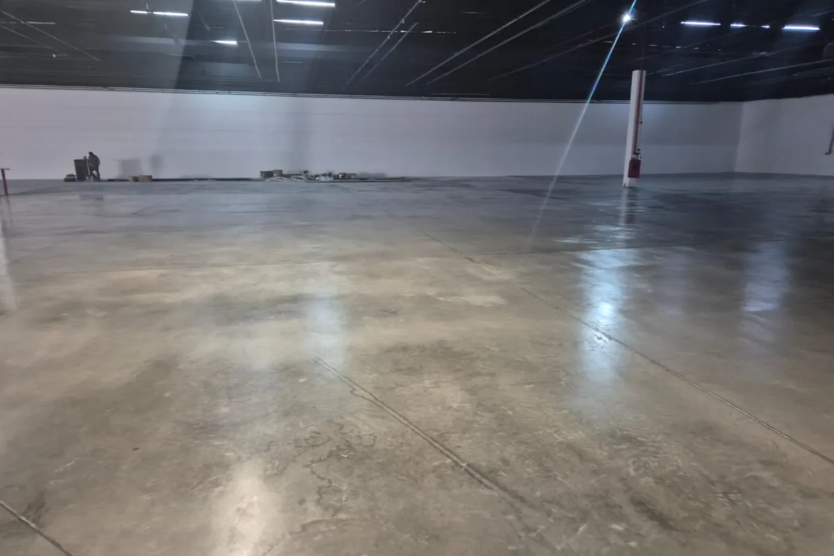 Galpão logístico com piso de concreto polido refletindo a iluminação