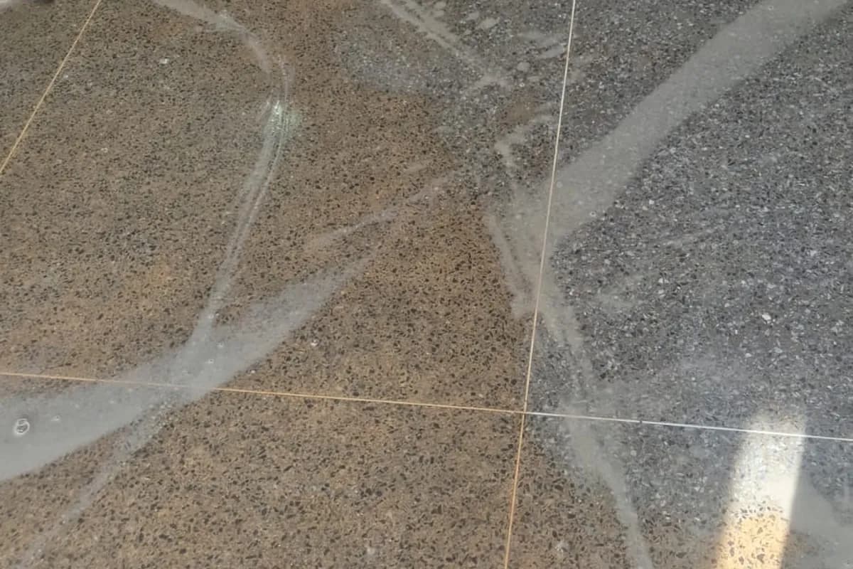 Piso de granitina polida em área comum, com junta metálica aparente